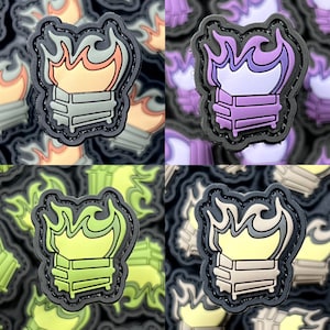 Puede incluir: Cuatro parches de diferentes colores con un contorno negro. Cada parche presenta un contenedor de basura en llamas con llamas de un color diferente: naranja, morado, verde y amarillo.