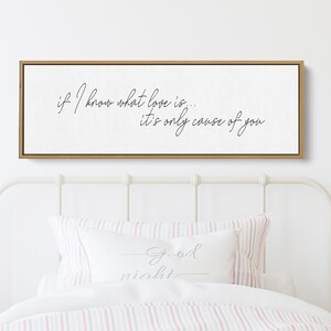 Pu&ograve; includere: Un cartello di legno bianco con calligrafia nera che recita "if I know what love is... it's only cause of you". Il cartello &egrave; appeso sopra un letto bianco con biancheria da letto a righe rosa e bianche.