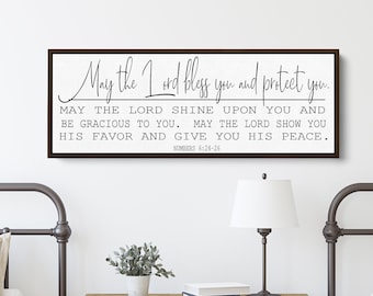 May include: A framed wood sign with a white background and black text. The text reads "May the Lord bless you and protect you. May the Lord shine upon you and be gracious to you. May the Lord show you His favor and give you His peace. Numbers 6:24-26"