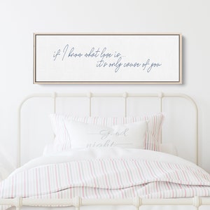 Pu&ograve; includere: Una stampa su tela bianca con una citazione in corsivo blu che recita "if I know what love is... it's only cause of you". La stampa &egrave; appesa sopra un letto bianco con biancheria da letto a righe rosa e bianche.