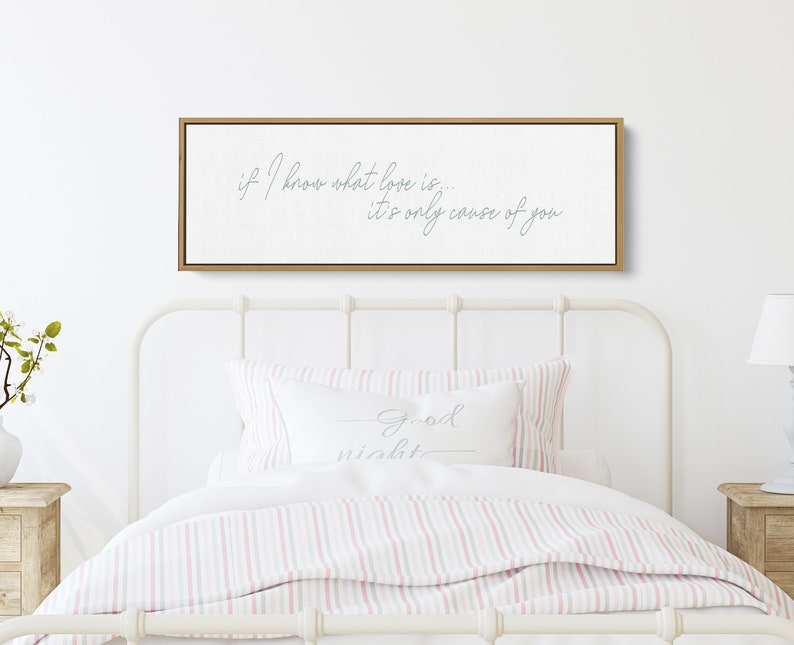 Pu&ograve; includere: Una stampa su tela bianca con cornice in legno, che presenta il testo "if I know what love is... it's only cause of you" in un carattere corsivo blu chiaro.