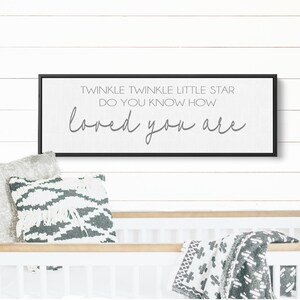 May include: A black framed sign with white background and gray text that reads "Twinkle Twinkle Little Star Do You Know How Loved You Are".