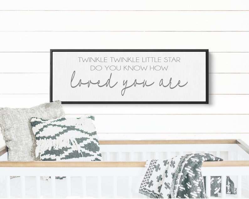 May include: A black framed sign with white background and gray text that reads "Twinkle Twinkle Little Star Do You Know How Loved You Are".