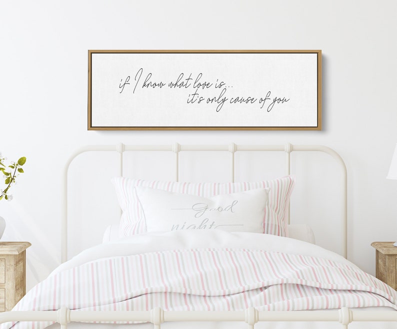 Pu&ograve; includere: Un cartello di legno bianco con calligrafia nera che recita "if I know what love is... it's only cause of you". Il cartello &egrave; appeso sopra un letto bianco con biancheria da letto a righe rosa e bianche.