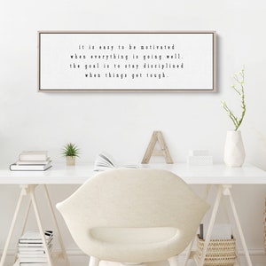 K&ouml;nnte beinhalten: Ein gerahmter Druck mit einem motivierenden Zitat in schwarzer Schrift auf wei&szlig;em Hintergrund. Das Zitat lautet: "it is easy to be motivated when everything is going well. the goal is to stay disciplined when things get tough."