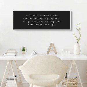 K&ouml;nnte beinhalten: Schwarzwei&szlig;es Motivationszitat auf einer gerahmten Leinwand. Das Zitat lautet: "Es ist leicht, motiviert zu sein, wenn alles gut l&auml;uft. Das Ziel ist es, diszipliniert zu bleiben, wenn es schwierig wird."