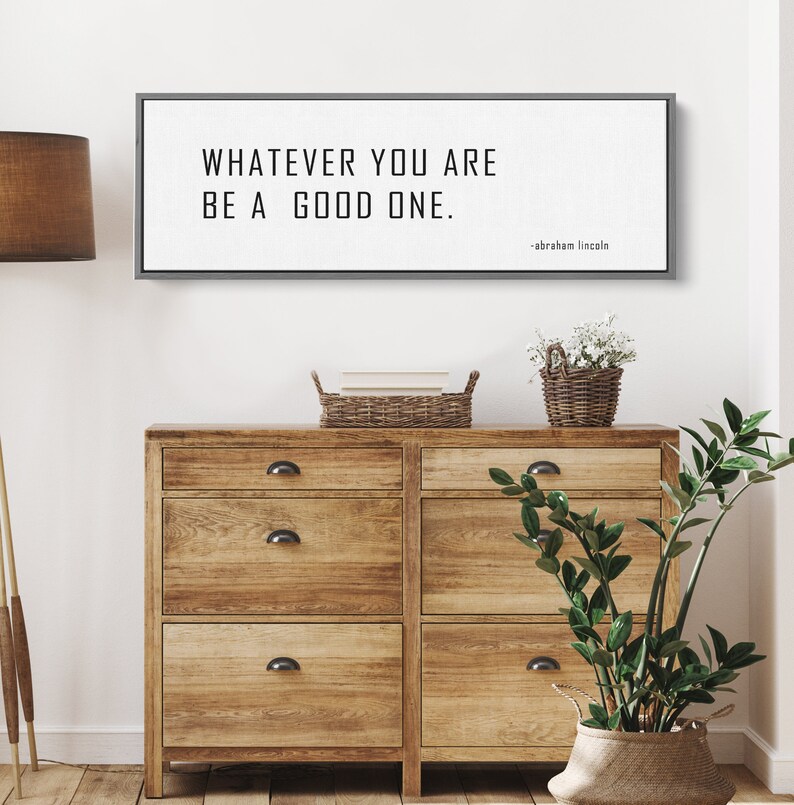 May include: A black and white framed print with the quote "Whatever you are, be a good one." attributed to Abraham Lincoln.