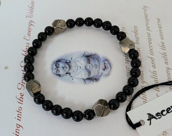 May include: A black beaded bracelet with silver metal accents. The bracelet is made of small, round black beads and features several silver metal charms in geometric shapes.
