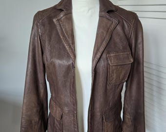 May include: A brown leather jacket with a zipper closure and multiple pockets. The jacket has a classic style and is made of high-quality leather.