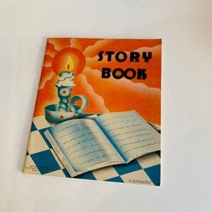 May include: A vintage orange and blue story book with the title "STORY BOOK" in black letters. The cover features a lit candle in a blue holder with red stars and a blue and white open book on a checkered background.