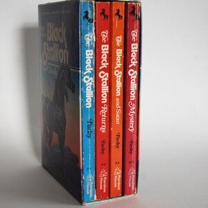 May include: A set of four paperback books in a slipcase. The books are all about The Black Stallion, a famous horse. The books are by Walter Farley and published by Random House.