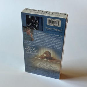 May include: A VHS tape of the movie "What Lies Beneath" featuring Harrison Ford and Michelle Pfeiffer. The cover has images of the actors and text that reads "Spine-Tingling!" and "Does For Bathtubs What Psycho Did For Showers!"