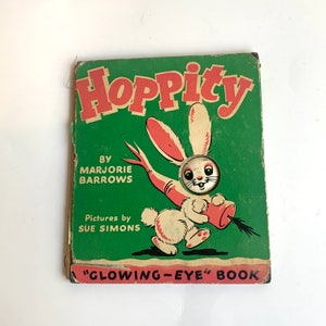 May include: A vintage children's book titled "Hoppity" with a green cover and a white rabbit with pink ears holding a red and white carrot. The book has the text "Glowing-Eye Book" on the bottom.