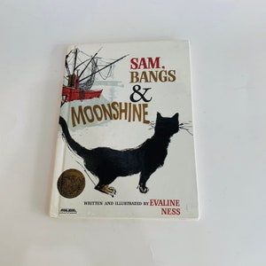 May include: A vintage children's book cover with a black cat and a red boat. The title is "Sam, Bangs & Moonshine" written in red and black lettering. The book is written and illustrated by Evaline Ness.