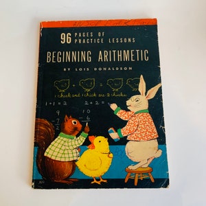 May include: Vintage book cover with a black chalkboard background featuring a rabbit, squirrel, and chicks. The book title is "Beginning Arithmetic" with 96 pages of practice lessons by Lois Donaldson.