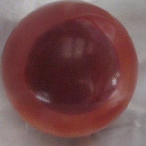 May include: A round, red and brown, smooth, shiny, decorative ball.