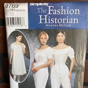 May include: A Simplicity sewing pattern titled "The Fashion Historian" featuring historical clothing designs. The pattern includes sizes HH 6, 8, 10, and 12. The cover displays images of women in white historical garments.
