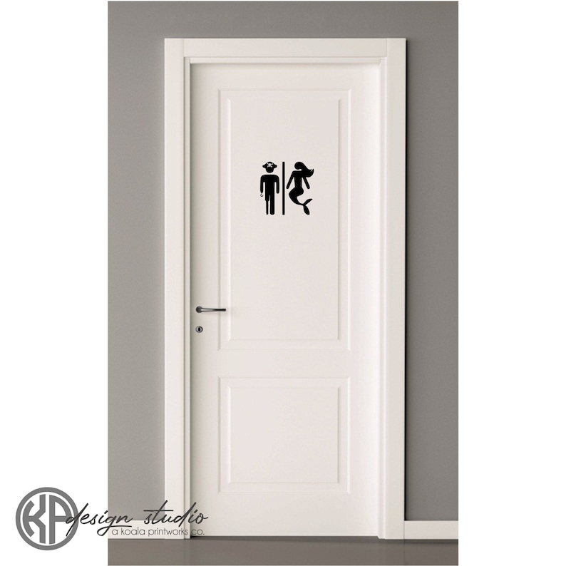 May include: A white door with a black silhouette of a mermaid and a man with a captain's hat on a white background. The text "design studio" is at the bottom of the image.