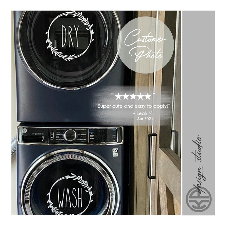 May include: A set of two white vinyl decals for a washer and dryer. The decals feature a wreath design with the words "WASH" and "DRY" in black script font. The decals are shown on a dark blue washer and dryer.