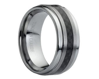Może przedstawiać: Srebrny pierścionek z węglika wolframu z czarną wkładką z włókna węglowego. Pierścionek jest grawerowany słowami "Tungsten Carbide".