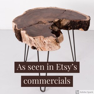 May include: A rustic wooden table with a live edge top and black hairpin legs. The table is made from a natural wood slice and has a unique, organic shape. "As seen in Etsy's commercials" is written in white text on a brown background.