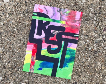 May include: A colorful abstract painting with the word "REST" written in black paint. The background is a mix of pink, red, green, and blue.
