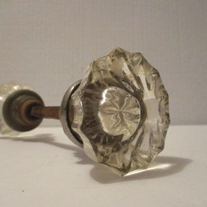 May include: A vintage glass door knob with a faceted design and a metal spindle.