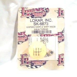 May include: A 6-speed ivory 2-inch shift knob with a 3/8-24 thread. The knob is packaged in a clear plastic bag with a white and yellow label that says "LOKAR, INC. SK-6873".