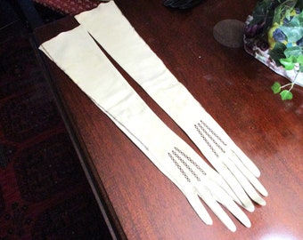 May include: A pair of long white leather gloves with delicate black stitching detail.