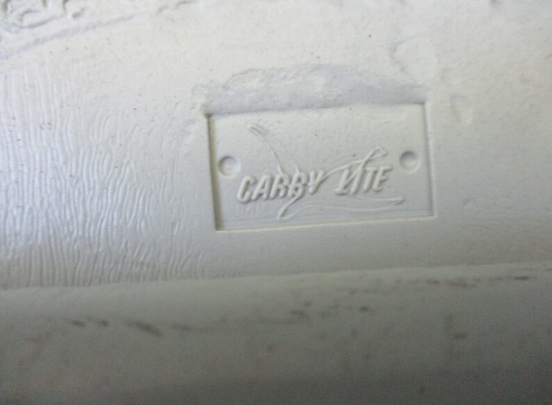 May include: Close-up of a white label with the text "CARRY LITE" in black lettering.