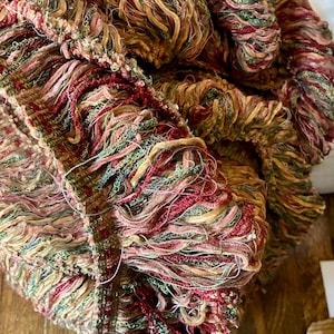 May include: A white ceramic mug with a black handle and the text "But First, Coffee" in a bold, black font. The mug is sitting on a wooden surface. The mug is approximately 4 inches tall.