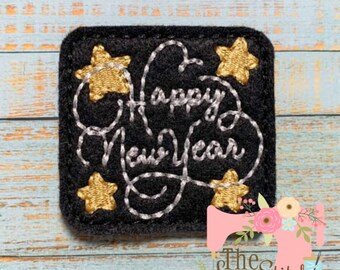 Puede incluir: Parche de fieltro negro con bordado blanco de las palabras "Happy New Year" y estrellas doradas.