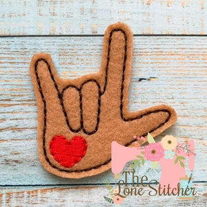 May include: Brown felt hand sign for "I love you" with a red heart in the palm of the hand.