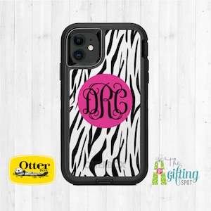May include: A black OtterBox phone case with a zebra print design and a pink circle with the monogram "DRC" in black.