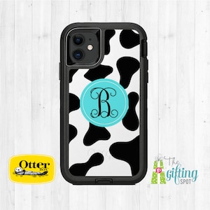 May include: Black and white cow print phone case with a turquoise circle containing a white monogram "B". The case is made by OtterBox.