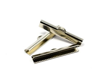 May include: Three silver metal slider buckles for straps or belts. The buckles have a serrated edge and a small loop on the top.