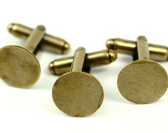 May include: Three antique brass cufflinks with a circular face and a T-bar closure. The cufflinks are displayed on a white background, showcasing their aged, metallic finish. These accessories are suitable for formal wear.