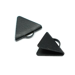 Puede incluir: Dos protectores de esquina de metal de forma triangular negra con borde redondeado.