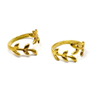 Puede incluir: Dos anillos ajustables de hoja de oro. Los anillos están abiertos y tienen un diseño delicado de hojas.