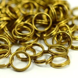 Könnte beinhalten: Ein Haufen goldfarbener Metall-Sprünge. Die Ringe sind klein und rund und eignen sich perfekt für die Schmuckherstellung oder andere Bastelarbeiten.