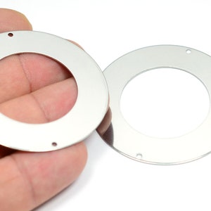 May include: Two silver metal rings with a hole on each side. The rings are about 2 inches in diameter.