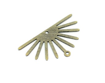 Könnte beinhalten: Ein goldfarbener Metall-Sonnenstrahlen-Anhänger mit einem Loch in der Mitte und einer kleinen Schlaufe unten. Der Anhänger ist so gestaltet, dass er wie eine Sonne aussieht, deren Strahlen von der Mitte ausstrahlen.