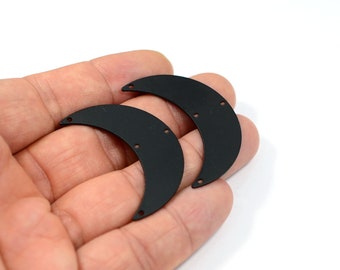 Könnte beinhalten: Zwei schwarze Halbmondformen aus Metall mit Löchern zum Anbringen an Schmuck oder anderen Bastelarbeiten.