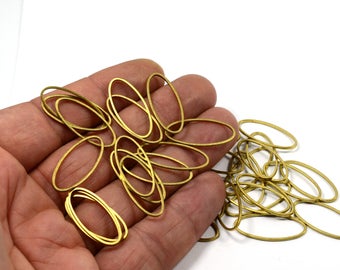 Può includere: Un grande mucchio di anelli ovali in metallo dorato. Gli anelli sono tutti della stessa dimensione e forma, e sono disposti in un motivo casuale.