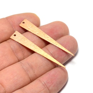 May include: Two gold-toned metal triangle-shaped earring blanks with a hammered texture.