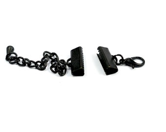 May include: Black metal chain with two black metal clasps and a black metal lobster claw clasp.