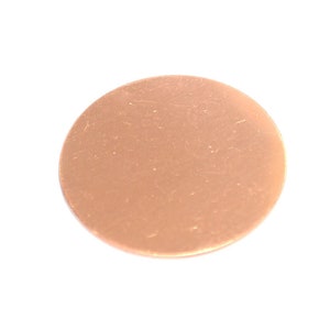 Puede incluir: Un disco redondo de color cobre sobre un fondo blanco. El disco tiene una superficie ligeramente texturizada y parece ser de metal. La forma es un círculo perfecto y el color es un tono metálico cálido.