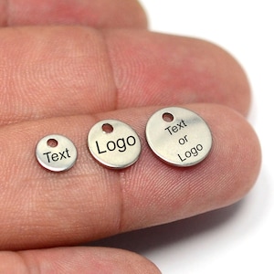 May include: Three silver metal round tags with holes for hanging. The smallest tag says "Text", the middle tag says "Logo", and the largest tag says "Text or Logo".