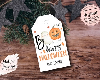 May include: A white Halloween gift tag with a watercolor ghost and jack-o'-lantern illustration. The tag reads "Be happy HALLOWEEN Love, Lawson" in orange and black lettering. The tag is surrounded by pine and star decorations.