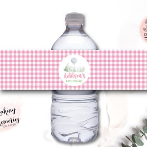 May include: Pink and white gingham water bottle label with a green and white golf ball graphic and the text "Addison's First Par-Tee".